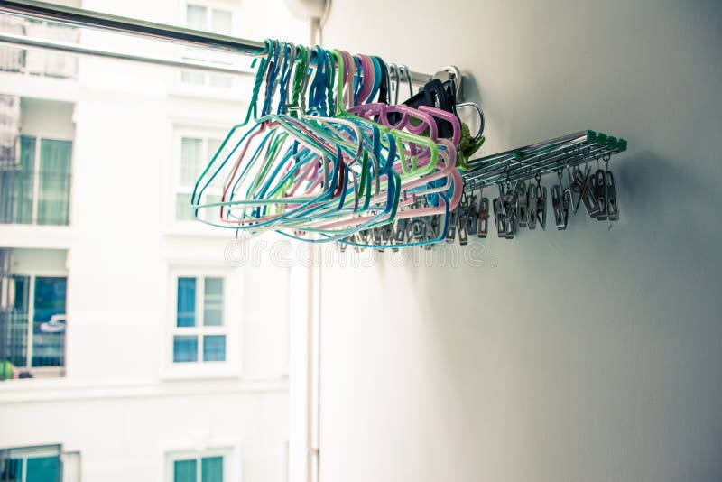 Las suspensiones de ropa y el acero inoxidable con los clips que cuelgan en la ropa atormentan en condominio o balcón del apartam imágenes de archivo libres de regalías Las suspensiones de ropa y el acero inoxidable con los clips que cuelgan en la ropa atormentan en condominio o balcón del apartam imágenes de archivo libres de regalías