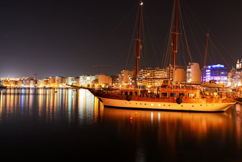 SLIEMA, MALTA - APRIL 21: The Hera cruises yacht and night view on Sliema, on April 21, 2015 in Sliema, Malta. More then 1,6 mln tourists is expected to visit Malta in year 2015. SLIEMA, MALTA - APRIL 21: The Hera cruises yacht and night view on Sliema, on April 21, 2015 in Sliema, Malta. More then 1,6 mln tourists is expected to visit Malta in year 2015