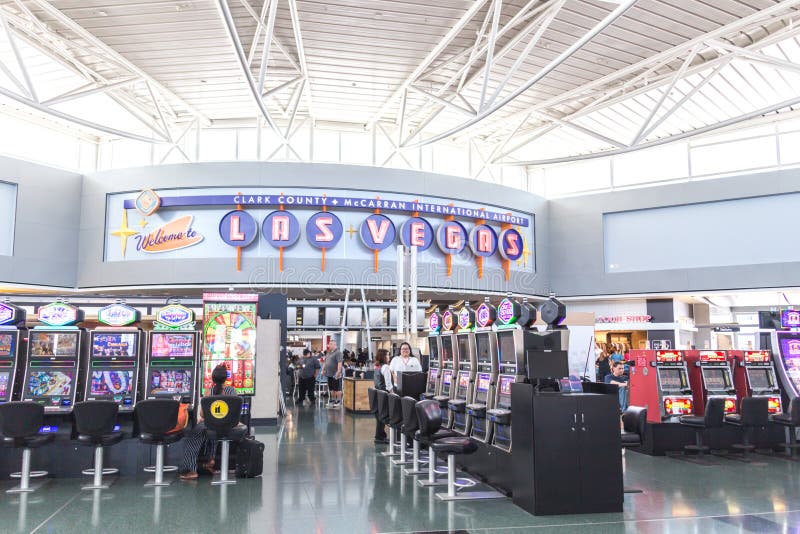 LAS VEGAS NEVADA, USA - 13 MAJ, 2019: Folk som spelar enarmade banditer på terminalen McCarran för internationell flygplats nedan royaltyfri bild LAS VEGAS NEVADA, USA - 13 MAJ, 2019: Folk som spelar enarmade banditer på terminalen McCarran för internationell flygplats nedan royaltyfri bild