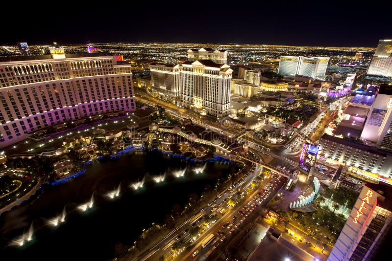 Aerial view looking down at the Intersection of Las Vegas Blvd and Flamingo Rd at night. Picture shows the Bellagio, Ballys, Caesars Palace, Mirage and Wynn Casinos. Time exposure shows motion blur on cars and people below.
