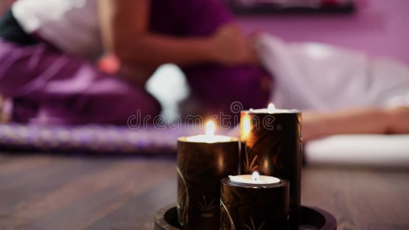Las velas arden cerca de la mujer que hace masaje en la pierna metrajes