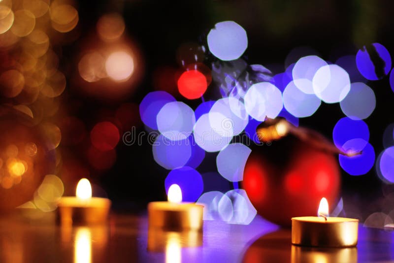 Las velas de oro de la Navidad y las chucherías rojas con el árbol que brilla se encienden foto de archivo Las velas de oro de la Navidad y las chucherías rojas con el árbol que brilla se encienden foto de archivo