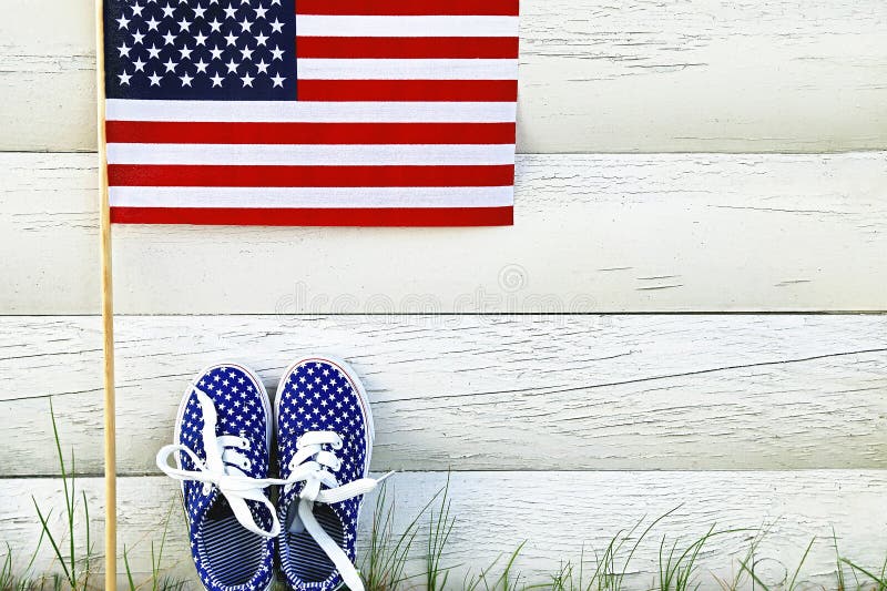 Las zapatillas de deporte de los niños americanos y bandera de los Estados Unidos de América fotos de archivo Las zapatillas de deporte de los niños americanos y bandera de los Estados Unidos de América fotos de archivo