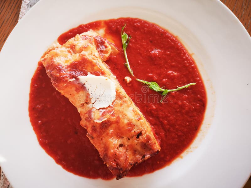 Lasagne in der Tomatensauce Geschmackvolle köstliche italienische Tellerlasagne mit Tomatensauce- und Frischkäse mit grünem salat lizenzfreies stockbild Lasagne in der Tomatensauce Geschmackvolle köstliche italienische Tellerlasagne mit Tomatensauce- und Frischkäse mit grünem salat lizenzfreies stockbild