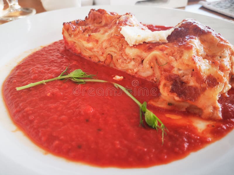 Lasagne in der Tomatensauce Geschmackvolle köstliche italienische Tellerlasagne mit Tomatensauce- und Frischkäse mit grünem salat stockfotografie Lasagne in der Tomatensauce Geschmackvolle köstliche italienische Tellerlasagne mit Tomatensauce- und Frischkäse mit grünem salat stockfotografie