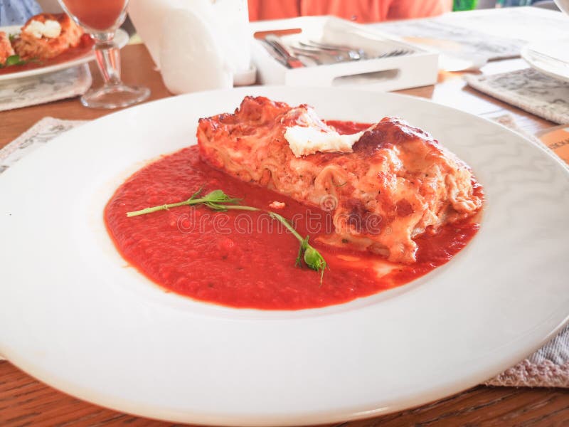 Lasagne in der Tomatensauce Geschmackvolle köstliche italienische Tellerlasagne mit Tomatensauce- und Frischkäse mit grünem salat lizenzfreies stockbild Lasagne in der Tomatensauce Geschmackvolle köstliche italienische Tellerlasagne mit Tomatensauce- und Frischkäse mit grünem salat lizenzfreies stockbild
