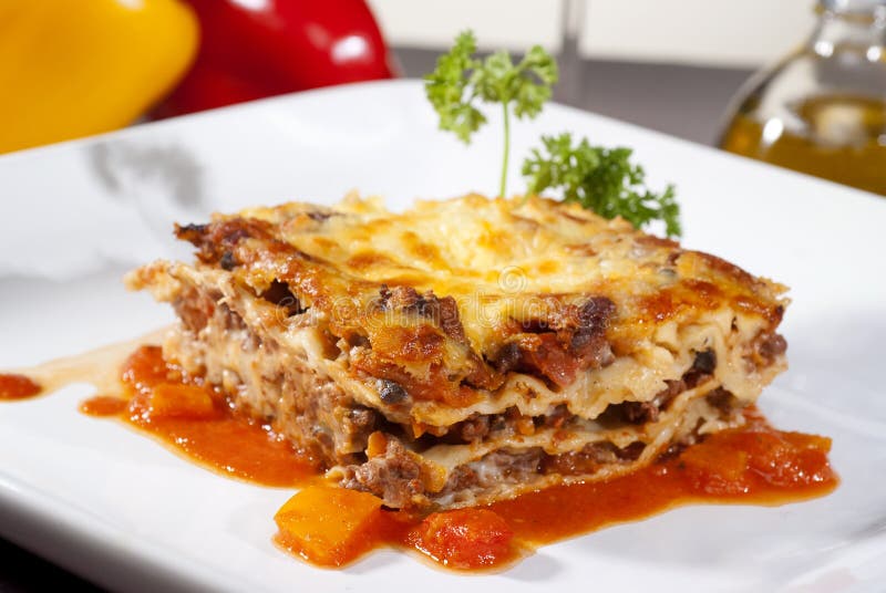 lasagner på en fyrkantig platta royaltyfri bild lasagner på en fyrkantig platta royaltyfri bild