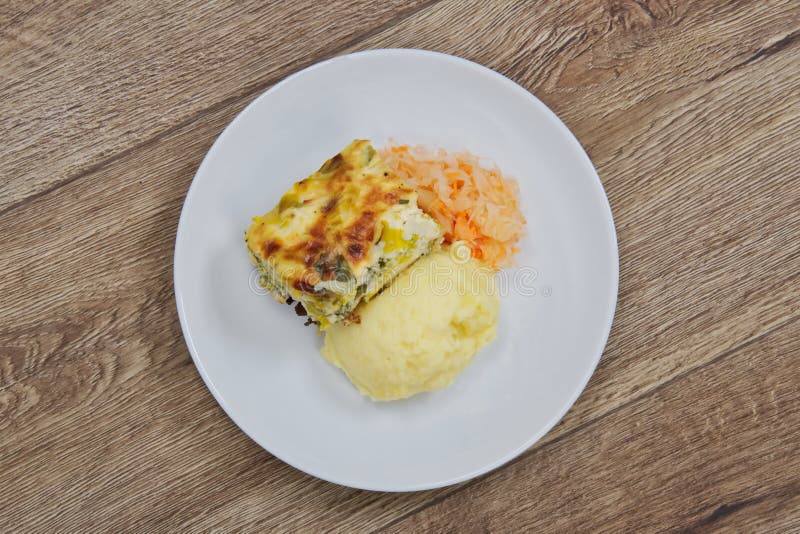 Lasanhas do alho-porro e erva-benta da batata em uma tabela imagens de stock Lasanhas do alho-porro e erva-benta da batata em uma tabela imagens de stock