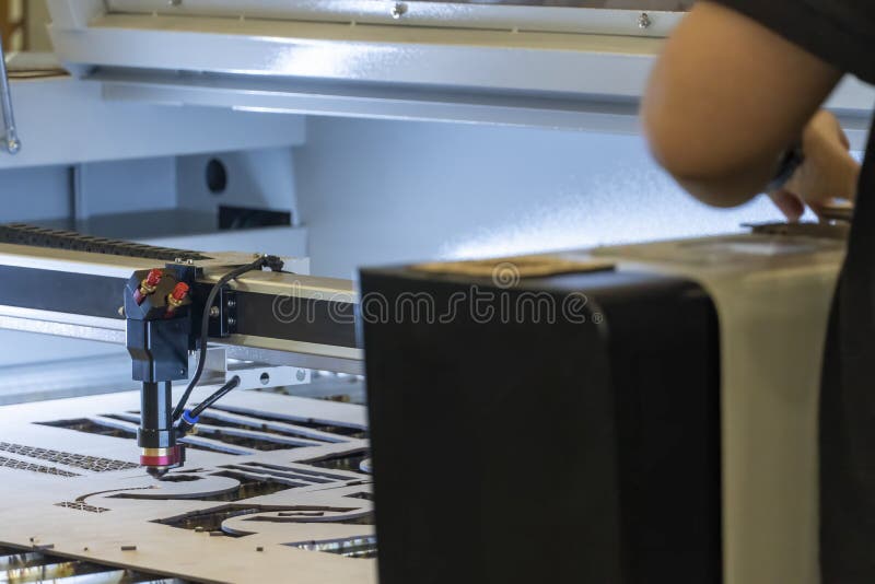 Laser Cutting Machine, Cutting Wood Sheets, while a Man Records the