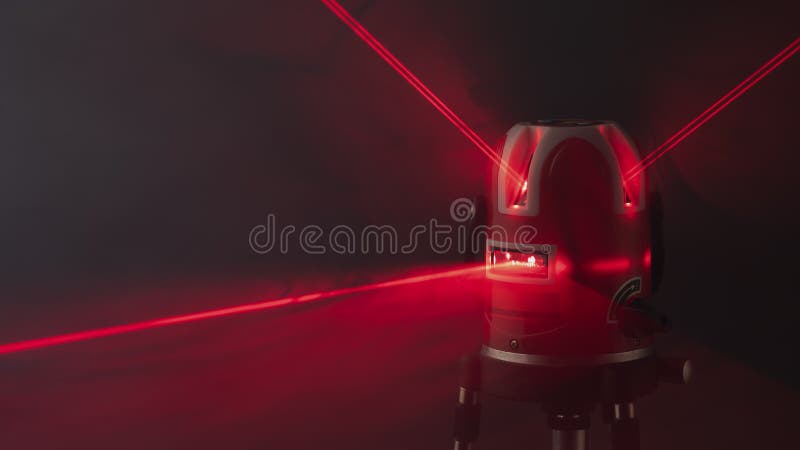 Laser level tool red light beams in smoke stock photography