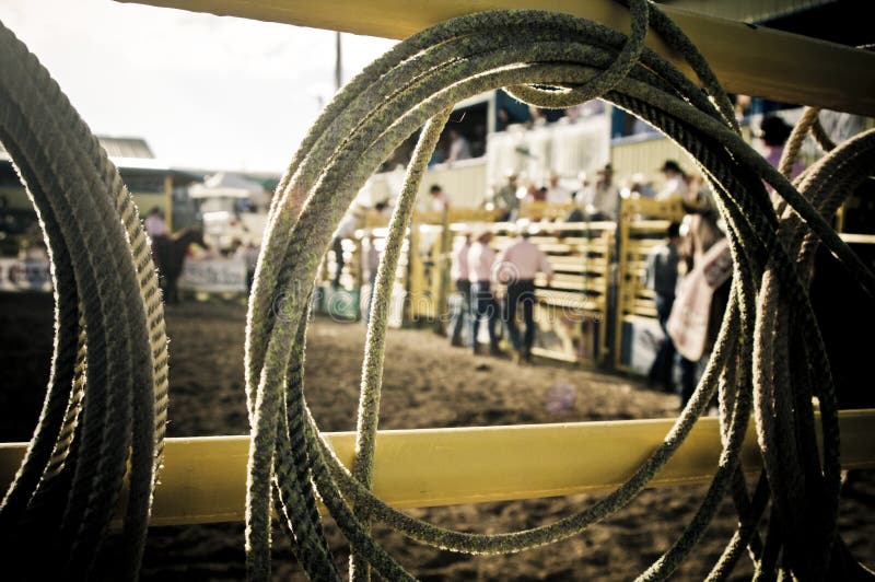 Abstract picture of a rodeo event focusing on the lasso rope. through the rope you can see cowboys. Abstract picture of a rodeo event focusing on the lasso rope. through the rope you can see cowboys