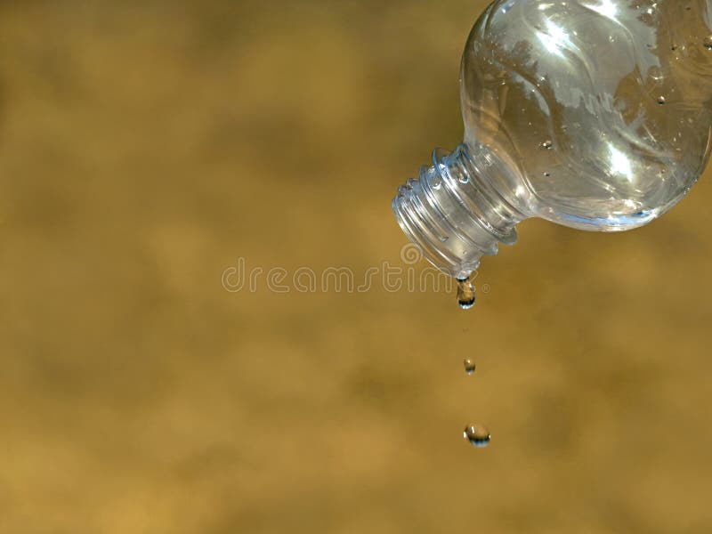 Last drop of water from empty plastic bottle on dried up grass background, close up, concept of water scarcity, drought