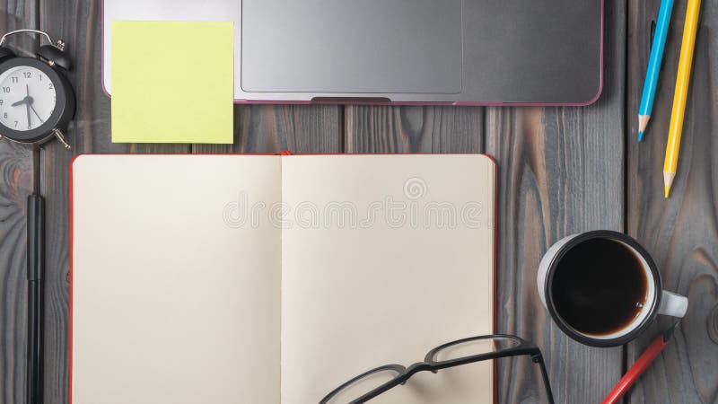 Lastra piatta di un paio di bicchieri vuoti aperti, matite colorate, penna, penna, una tazza di caffè, portatile con un adesivo gi fotografie stock