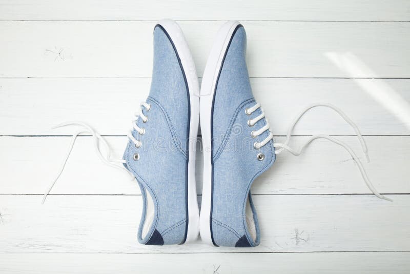Lat przypadkowi sneakers na bia?ym drewnianym tle zdjęcie stock Lat przypadkowi sneakers na bia?ym drewnianym tle zdjęcie stock
