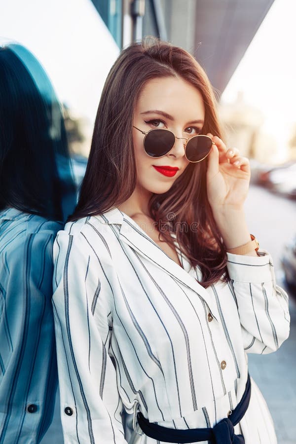 Lata styl życia mody pogodny portret młoda elegancka modniś kobieta chodzi na ulicie z okularami przeciwsłonecznymi, jest ubranym zdjęcie royalty free Lata styl życia mody pogodny portret młoda elegancka modniś kobieta chodzi na ulicie z okularami przeciwsłonecznymi, jest ubranym zdjęcie royalty free