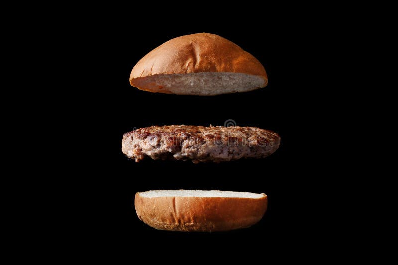 Latający hamburger z babeczką i pasztecikiem odizolowywającymi na czarnym tle