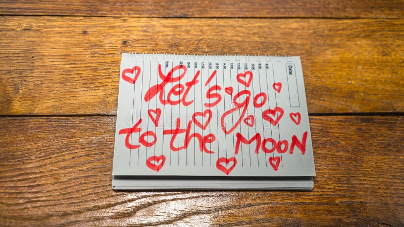 Let`s go to the moon, writing love text on paper, lovely message. Text on spiral agenda. Romantic, love concept. Valentine`s day. Let`s go to the moon, writing love text on paper, lovely message. Text on spiral agenda. Romantic, love concept. Valentine`s day