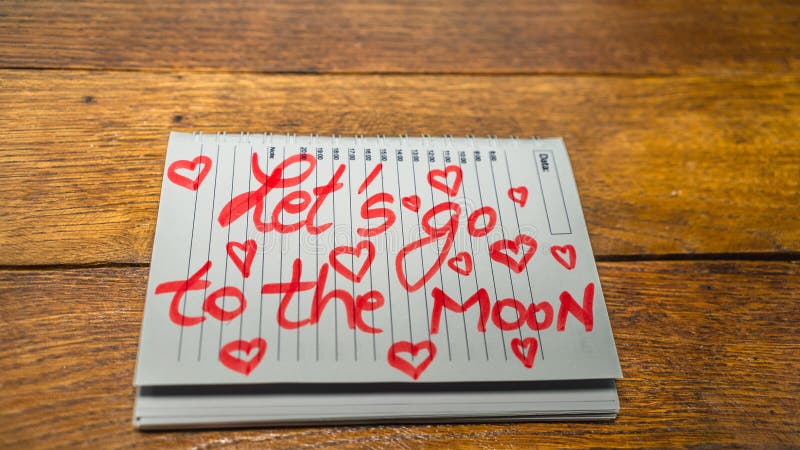 Let`s go to the moon, writing love text on paper, lovely message. Text on spiral agenda. Romantic, love concept. Valentine`s day. Let`s go to the moon, writing love text on paper, lovely message. Text on spiral agenda. Romantic, love concept. Valentine`s day
