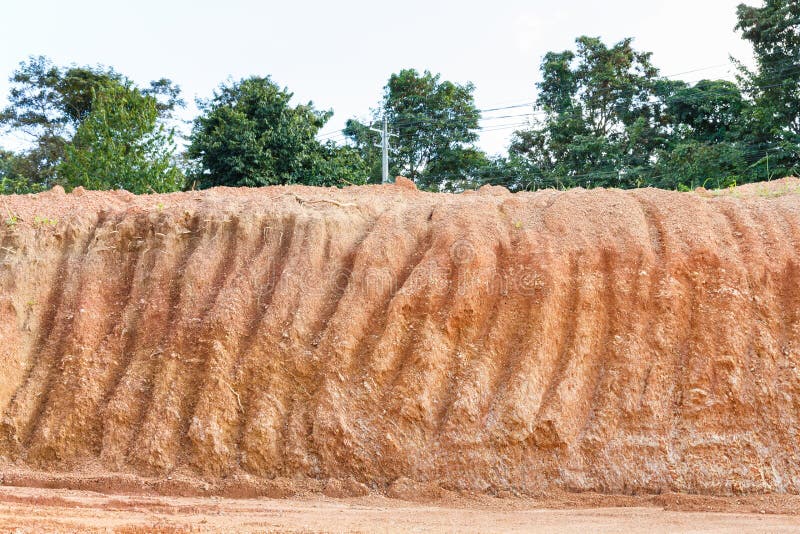 Close up red color lateritic soil cross section. Close up red color lateritic soil cross section