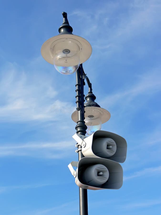 Closeup of the retro lamppost with two loud-speakers with the beauty blue sky in the background. Closeup of the retro lamppost with two loud-speakers with the beauty blue sky in the background.