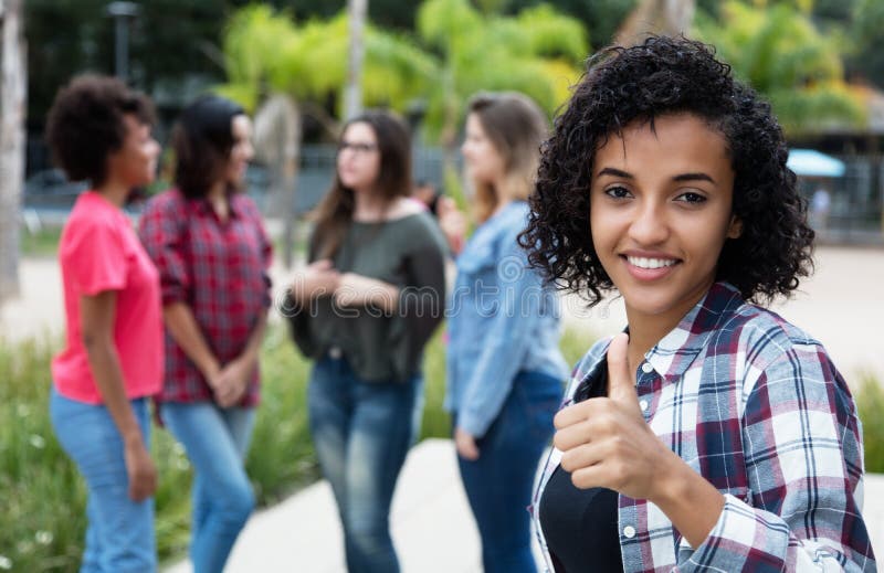 Latin american woman showing thumb with group of girlfriends. Latin american women showing thumb with group of girlfriends outdoors in the summer in the city royalty free stock images Latin american woman showing thumb with group of girlfriends. Latin american women showing thumb with group of girlfriends outdoors in the summer in the city royalty free stock images
