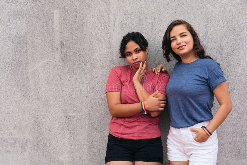 Latin Lesbian Couple Standing On A City Street While Enjoying A Day