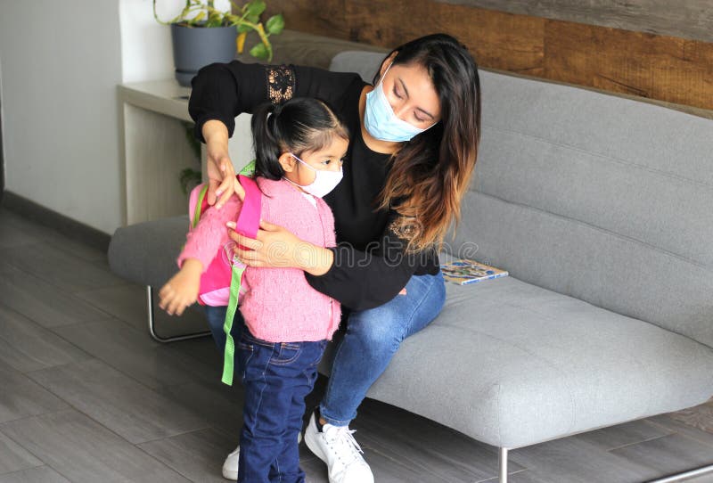 Latin mom and 3 year old girl with protective face masks and backpack for back to school, new normal covid-19