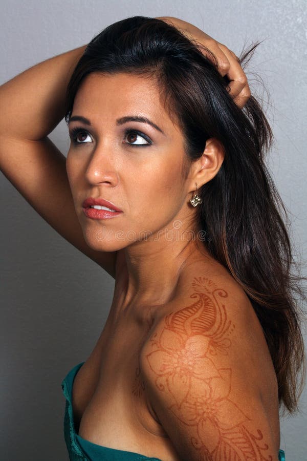 Close-up of a lovely young Latina with faded Henna tattoo artwork on her left shoulder. Close-up of a lovely young Latina with faded Henna tattoo artwork on her left shoulder.