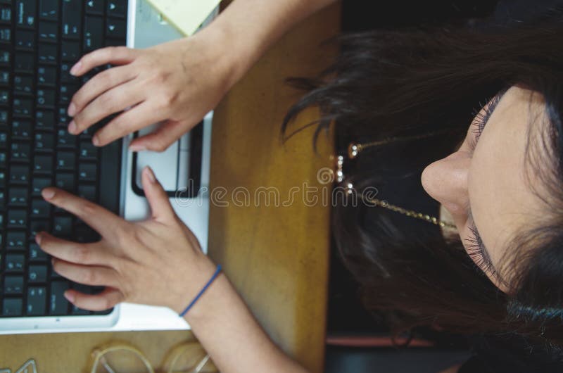Latinamerikansk brunettkontorskvinna som arbetar på bärbara datorn