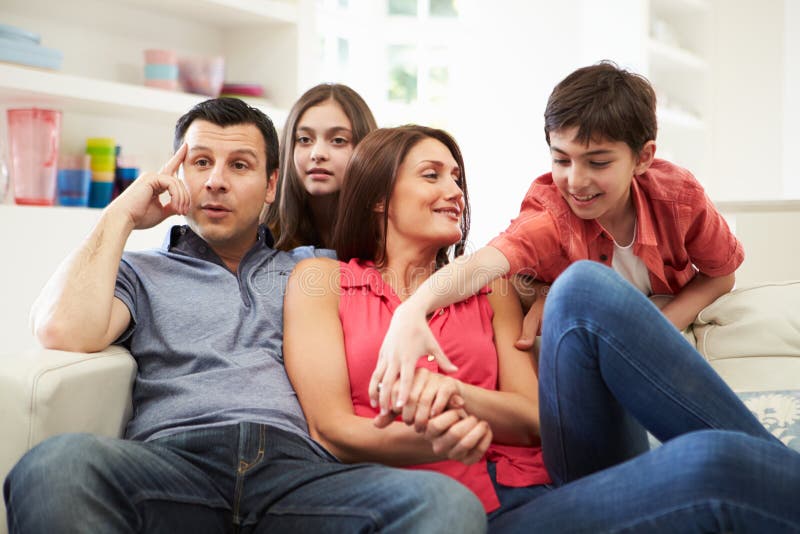 Latinamerikansk familj på Sofa Watching TV tillsammans royaltyfri fotografi Latinamerikansk familj på Sofa Watching TV tillsammans royaltyfri fotografi