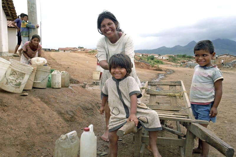 Latino mother, children fetch water, wheelbarrow