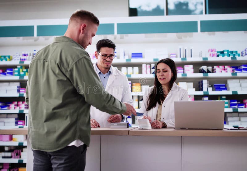 Latino Pharmacist Securely Processes Debit Card Payment stock image