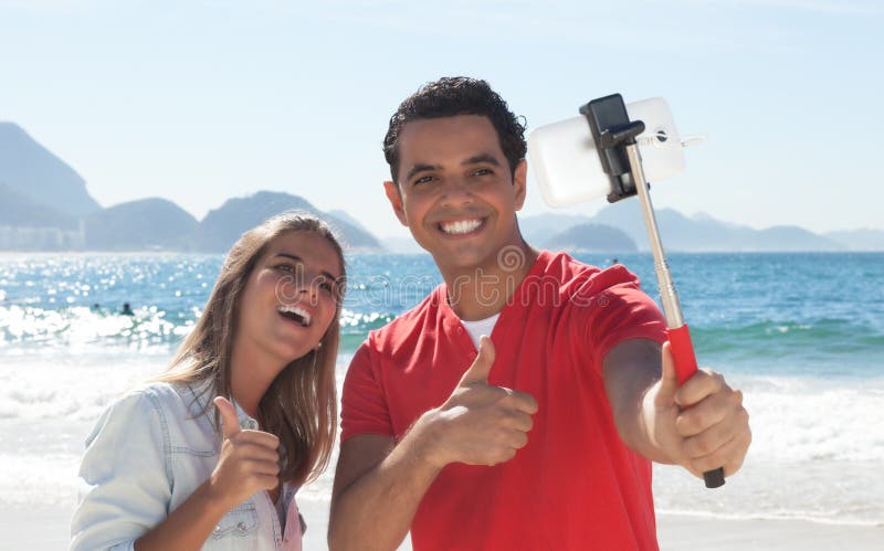 Latinsk parvisningtumme och taselfie med telefonen royaltyfria foton Latinsk parvisningtumme och taselfie med telefonen royaltyfria foton