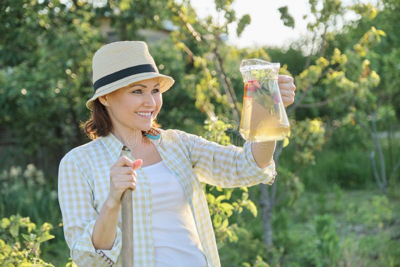 Lato plenerowy portret kobieta z naturalnym napojem robić od truskawki mennicy ziele, kobiety ogrodnictwo fotografia stock Lato plenerowy portret kobieta z naturalnym napojem robić od truskawki mennicy ziele, kobiety ogrodnictwo fotografia stock