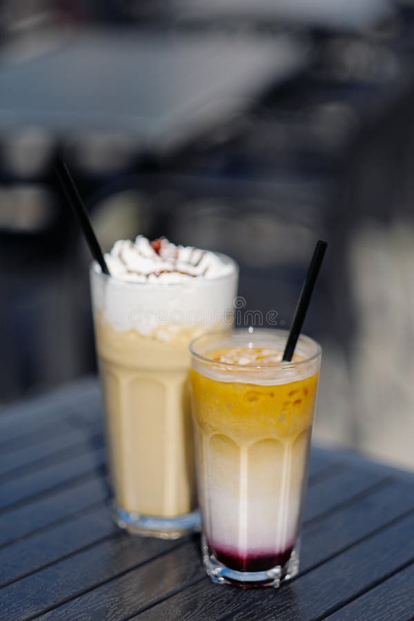 Latte com chantiliy e o cocktail leitoso da baga com amoras-pretas e caramelo imagem de stock Latte com chantiliy e o cocktail leitoso da baga com amoras-pretas e caramelo imagem de stock