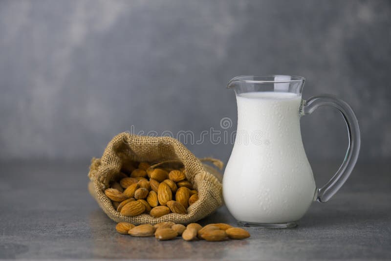 Latte della mandorla in barattolo con le mandorle in tela di sacco fotografia stock Latte della mandorla in barattolo con le mandorle in tela di sacco fotografia stock