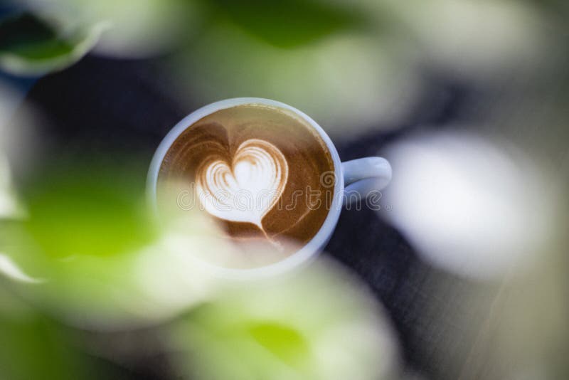 Latte en forma de corazón del café en la tabla de madera imagenes de archivo Latte en forma de corazón del café en la tabla de madera imagenes de archivo