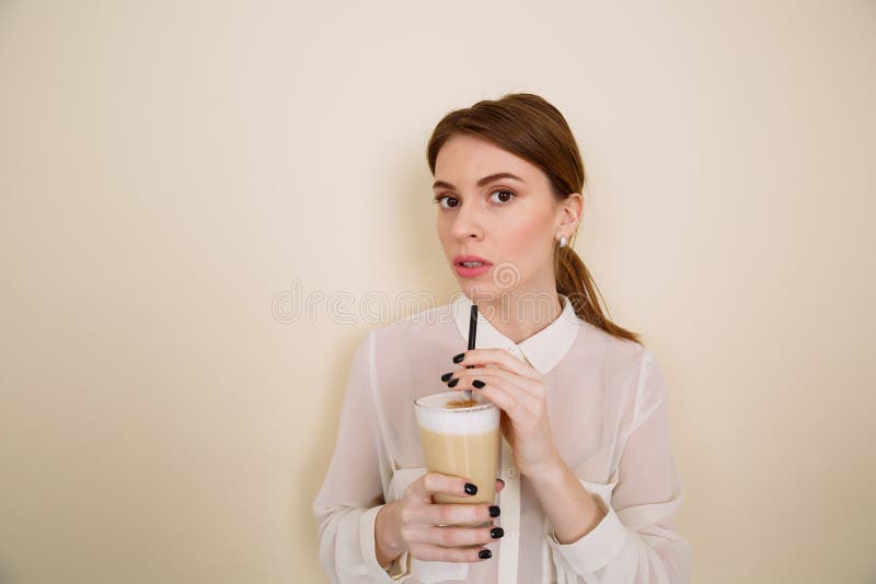 Latte potable de café de jeune femme attirante de verre avec la paille photo libre de droits