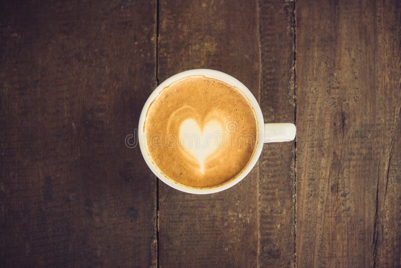 Lattekonstkaffe på den wood tabellen royaltyfria foton