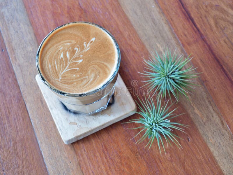 Lattekonstkaffe på det wood tefatet arkivfoto