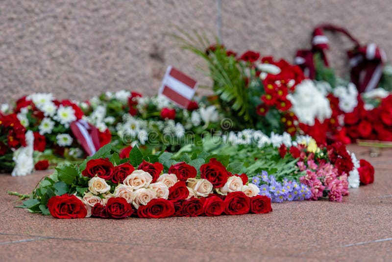 Latvia 100 years. Red and white flowers compositions at the Freedom Monument in city Riga, Latvia.