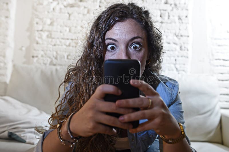 Latynoski kobiety mienia telefon komórkowy w szalonych oczach sieci i interneta ogólnospołeczny nałogu pojęcie zdjęcia royalty free Latynoski kobiety mienia telefon komórkowy w szalonych oczach sieci i interneta ogólnospołeczny nałogu pojęcie zdjęcia royalty free