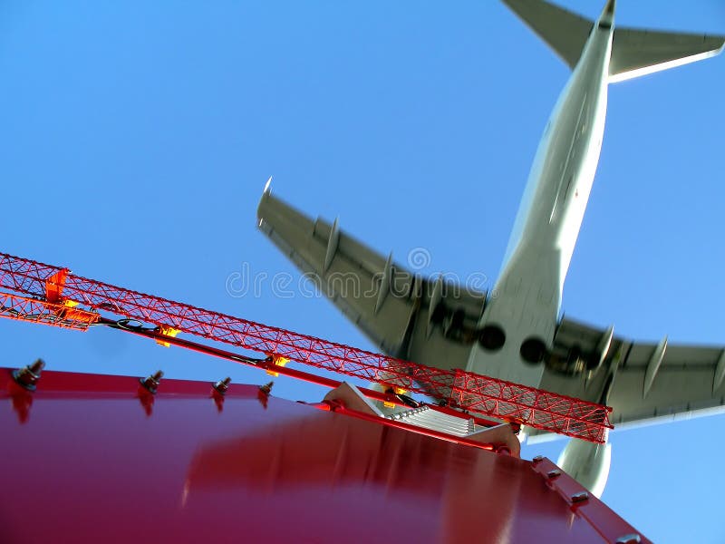 Upward view from below a light tower into the sky where an airplane is passing right above seconds before touching the runway. Focus at top of the tower. Plane in motion showing some motion blurr. Upward view from below a light tower into the sky where an airplane is passing right above seconds before touching the runway. Focus at top of the tower. Plane in motion showing some motion blurr.