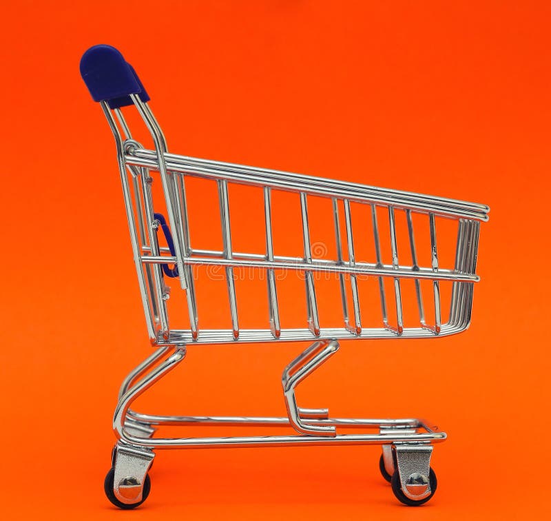 Laufkatzenwarenkorb des Selbstbedienungssupermarktes voller Einkaufsauf buntem Hintergrund stockfoto