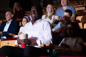 Laughing African American Man Watching Comedy In Movie Theater Stock 
