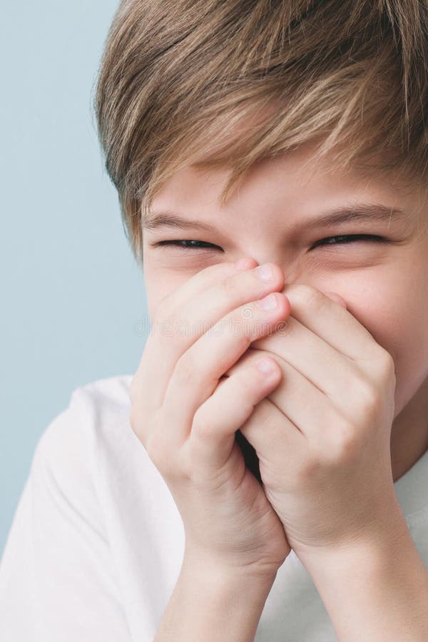 Laughing boy covers his mouth with his hands royalty free stock photography Laughing boy covers his mouth with his hands royalty free stock photography
