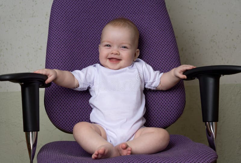 Laughing child sits on the office chair