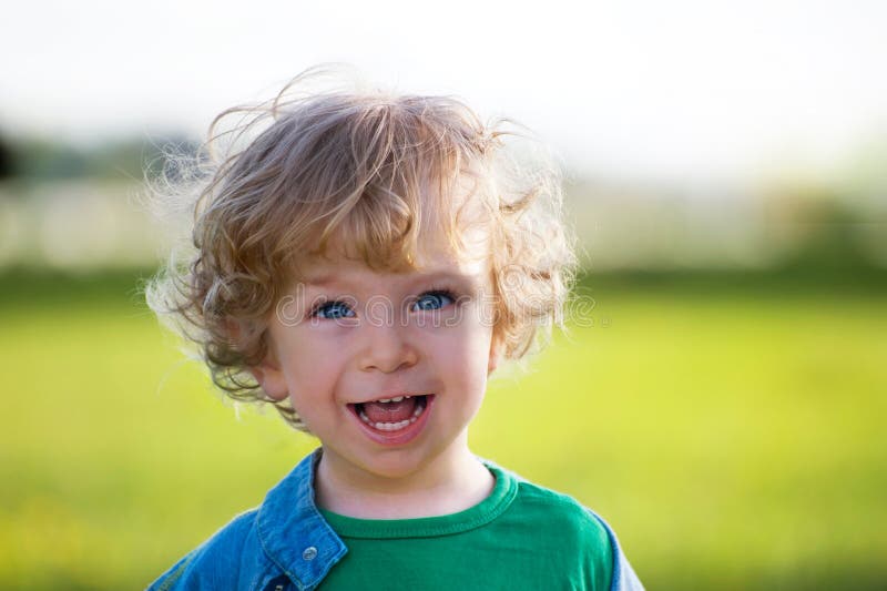 Laughing child on a summer meadow royalty free stock photo