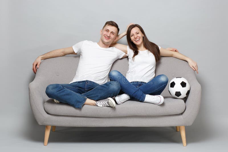 Laughing couple woman man football fans in white t-shirt cheer up support favorite team with soccer ball, hugging