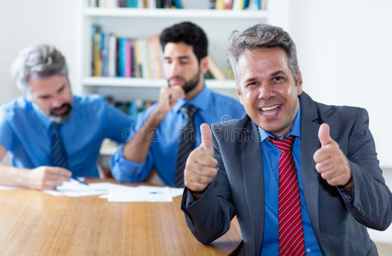 Laughing elderly businessman with motivated team at office stock photography